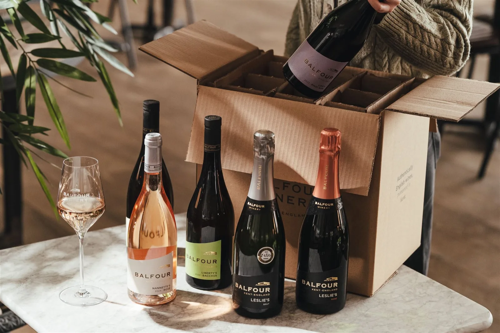 Bottles of Balfour sparkling wine beside a lit candle on a table
